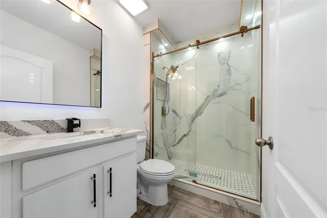 a bathroom with a granite countertop sink toilet and shower