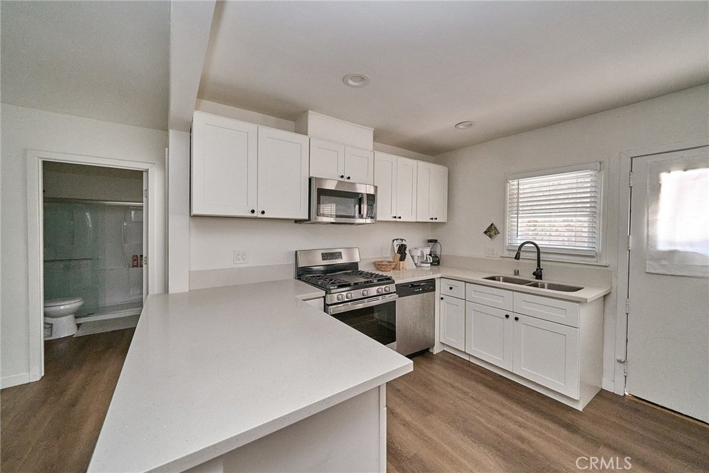 8734 Ramsgate Avenue Los Angeles, CA 90045 - Photo 6 of 19 a kitchen with stainless steel appliances a sink stove and cabinets