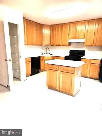 a kitchen with stainless steel appliances a stove a sink and a microwave