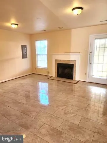 an empty room with windows and fireplace