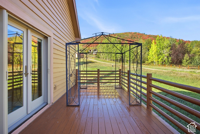 7396 Brook Hollow Loop Road Park City, UT 84098 - Photo 15 of 60 Wood-finish deck with a metal gazebo and wood railing, complemented by horizontal siding and glass-paneled double doors