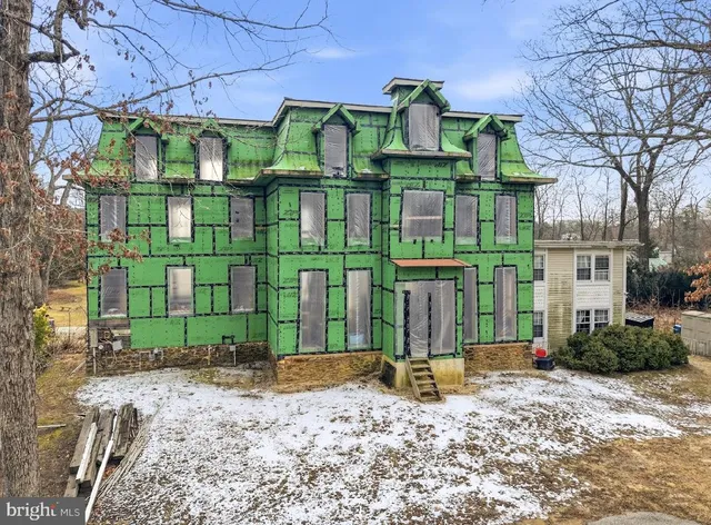 a view of a brick house with large windows and a small yard