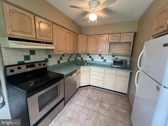 a kitchen with granite countertop a sink stainless steel appliances and cabinets