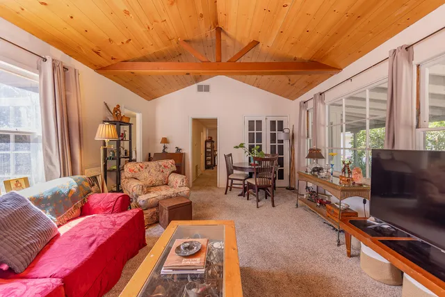 a living room with furniture a flat screen tv and large window