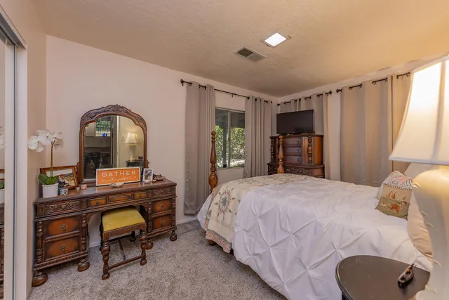 a bedroom with a bed and a dresser with mirror