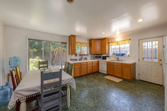 a kitchen with a table chairs sink and cabinets