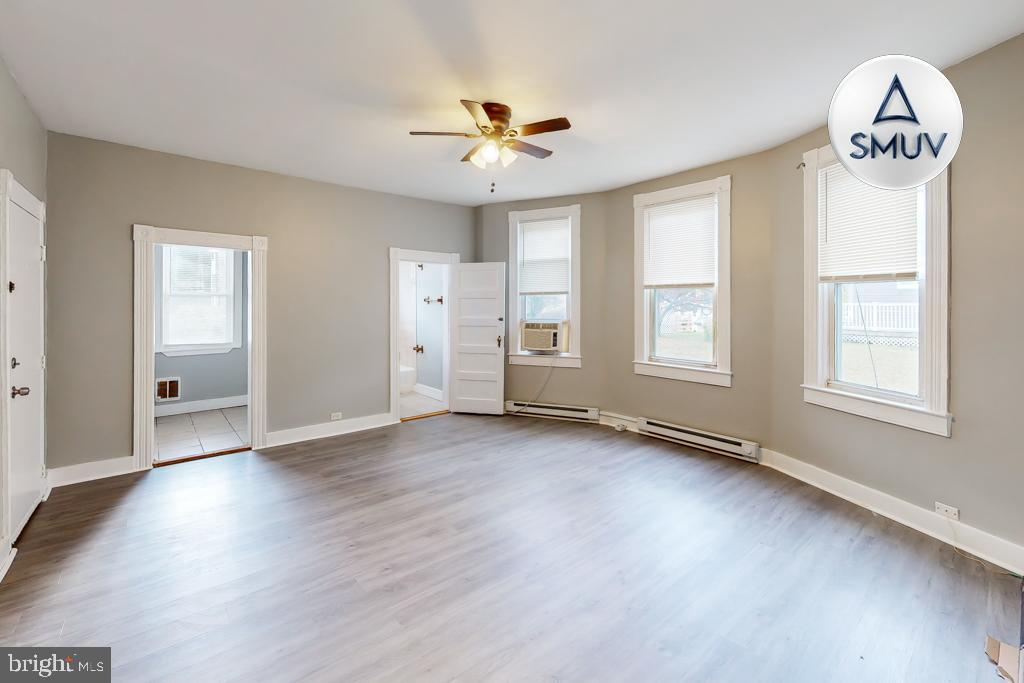 14 East Overlea Avenue, Unit 1 Baltimore, MD 21206 - Photo 15 of 15 an empty room with wooden floor fan and windows