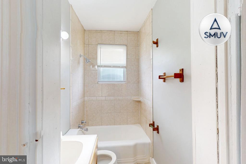 14 East Overlea Avenue, Unit 1 Baltimore, MD 21206 - Photo 3 of 15 a bathroom with a sink a toilet and shower