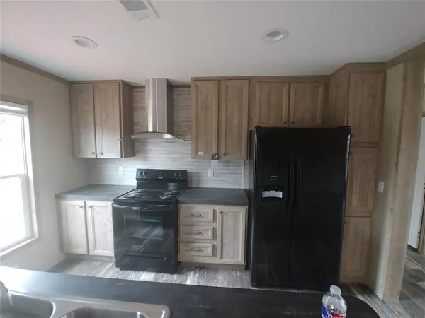 a kitchen with a refrigerator and a stove top oven