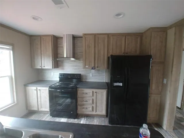 a kitchen with a refrigerator and a stove top oven