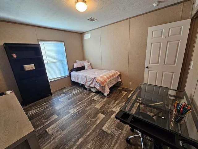 a bedroom with a bed and wooden floor