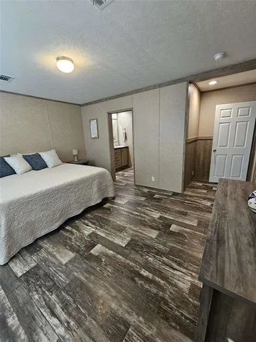 a spacious bedroom with a bed and a dresser