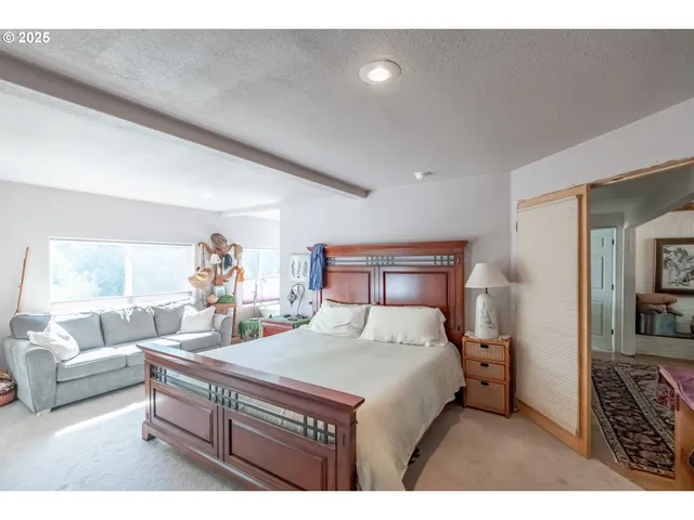 a bedroom with a bed a couch and a large window