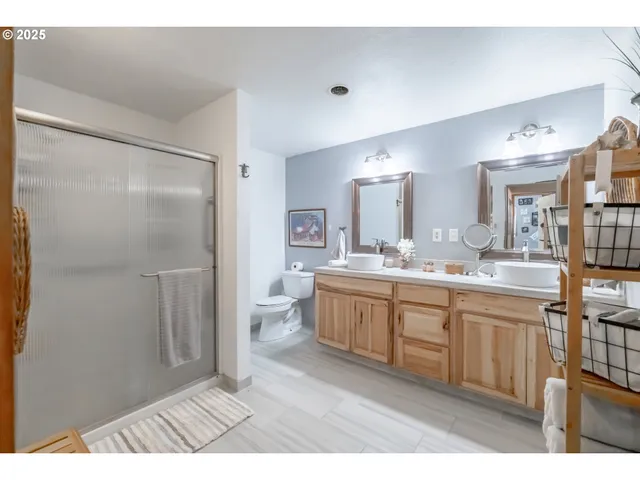 a spacious bathroom with a double vanity sink a mirror and a shower