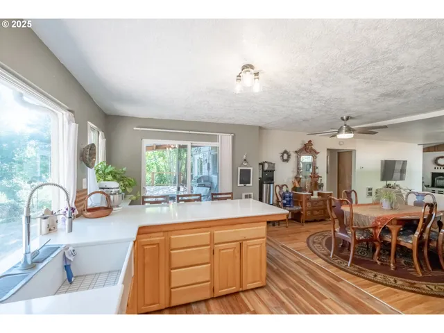 a room with lots of tables a large window and chairs