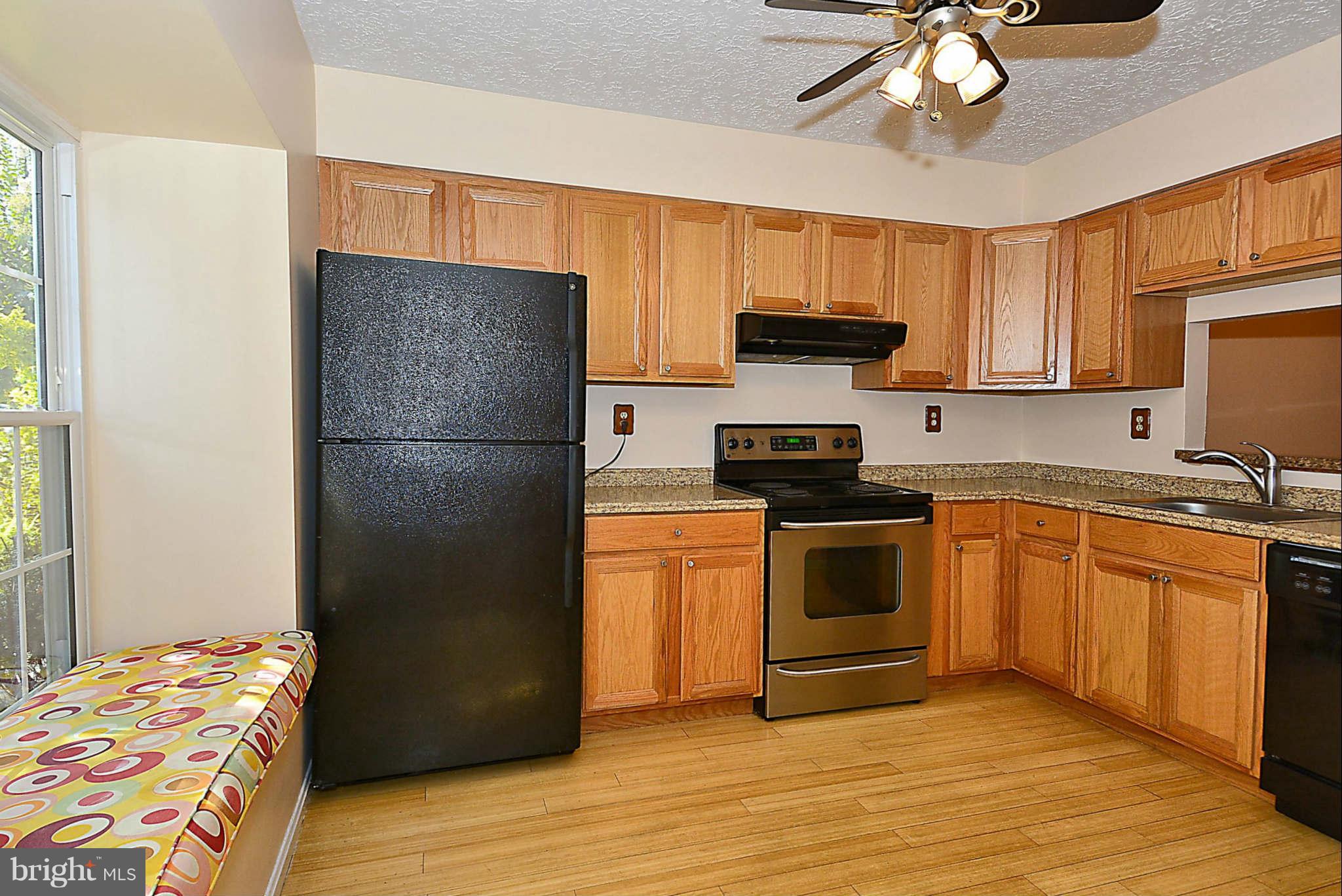 11457 Encore Drive Silver Spring, MD 20901 - Photo 5 of 27 a kitchen with stainless steel appliances granite countertop a refrigerator stove top oven a sink and dishwasher