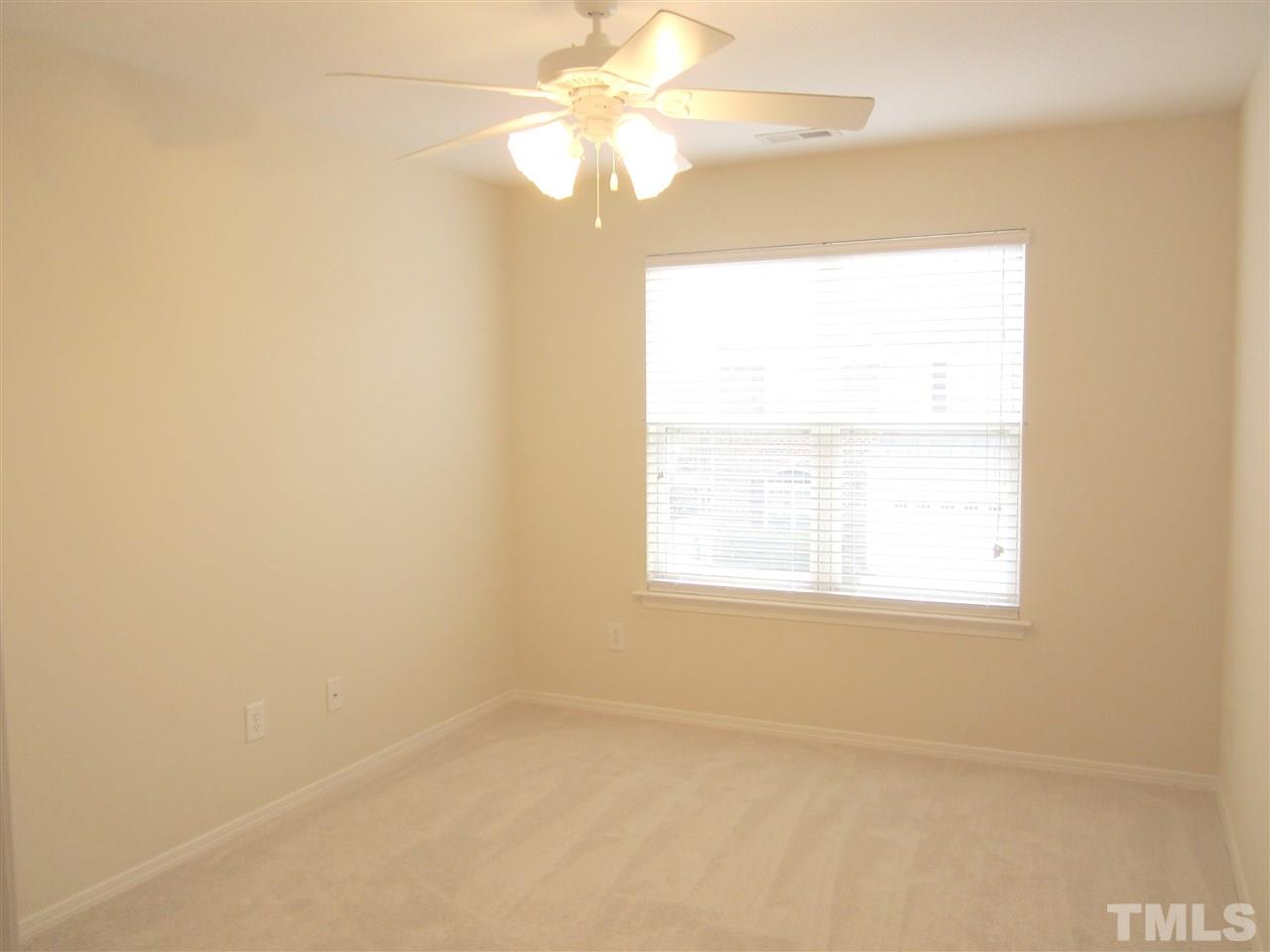 8217 Beaded Stone Street Raleigh, NC 27613 - Photo 14 of 16 an empty room with a window and a fan