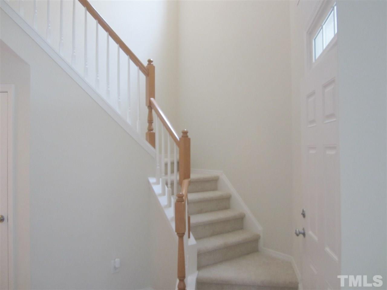 8217 Beaded Stone Street Raleigh, NC 27613 - Photo 3 of 16 a view of staircase with white walls and white walls