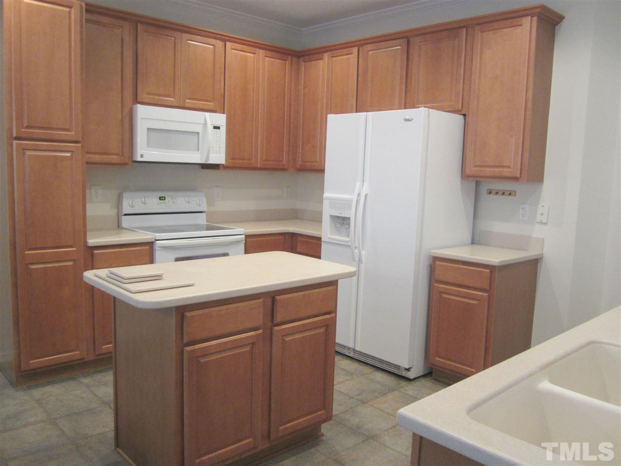8217 Beaded Stone Street Raleigh, NC 27613 - Photo 6 of 16 a kitchen with a white stove top oven and refrigerator