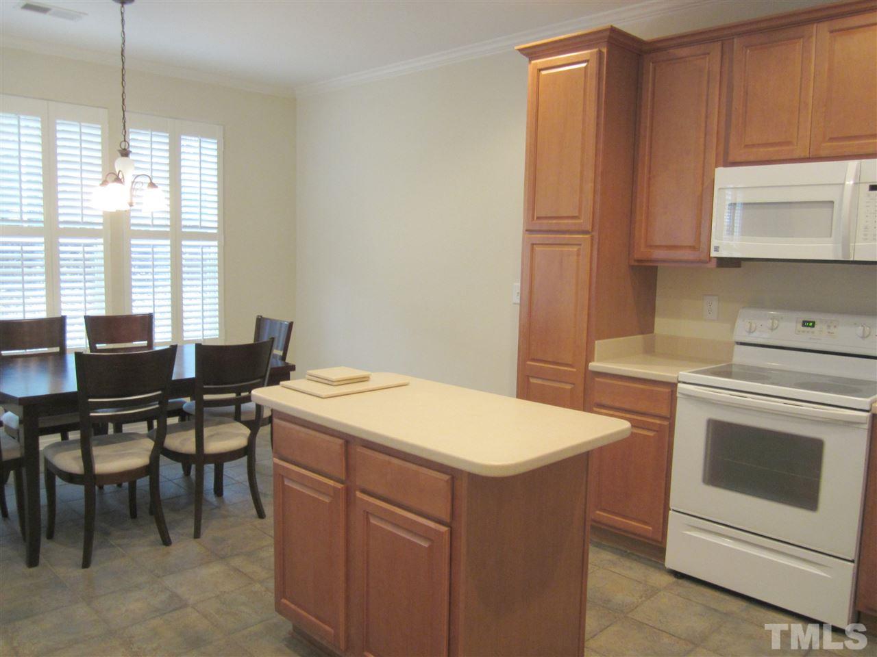8217 Beaded Stone Street Raleigh, NC 27613 - Photo 8 of 16 a kitchen that has a stove and a table in it