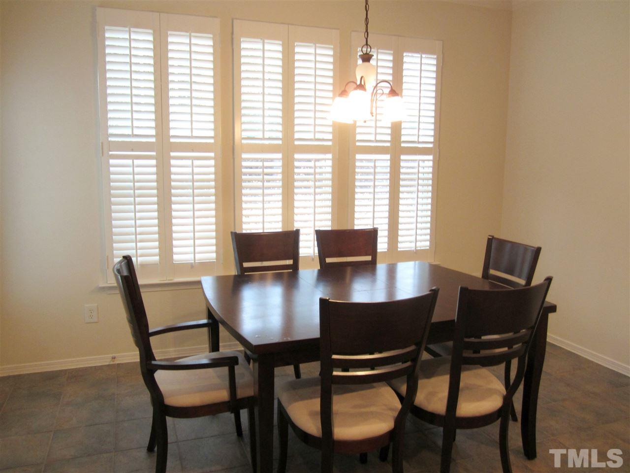 8217 Beaded Stone Street Raleigh, NC 27613 - Photo 9 of 16 a view of a dining room with furniture and a window