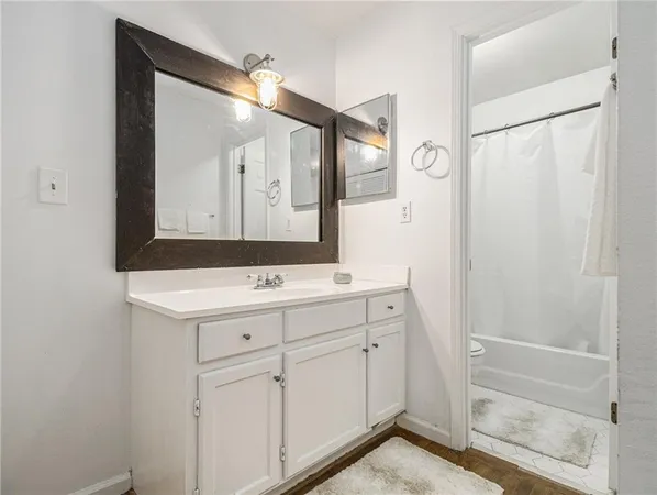 a bathroom with a sink a mirror a vanity and a shower