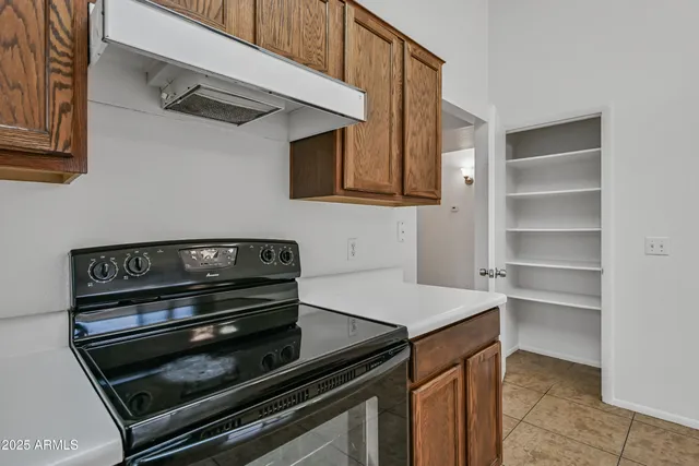 a kitchen with wooden cabinets and a stove top oven