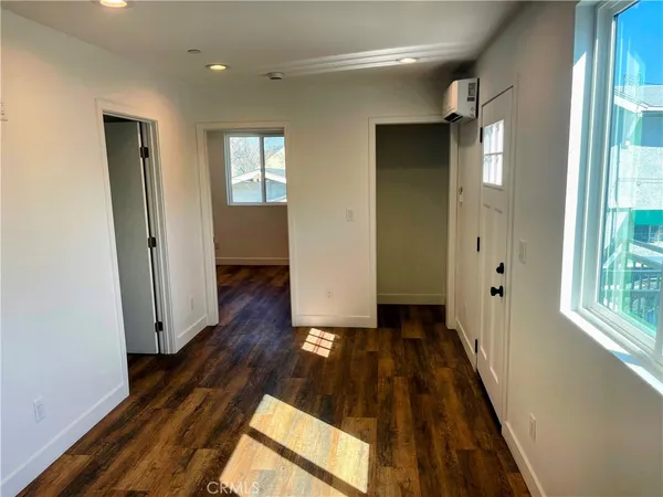 a view of a hallway with wooden floor and stairs