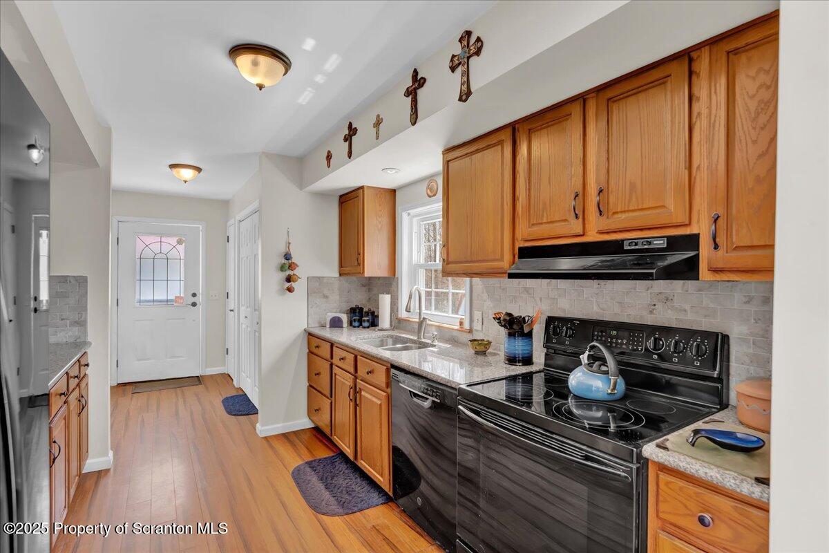 3330 Quicktown Road Moscow, PA 18444 - Photo 5 of 34 a kitchen with granite countertop a stove a sink dishwasher and cabinets with wooden floor