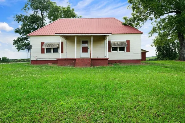 a front view of a house with a garden and yard