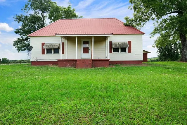 a front view of a house with a garden and yard