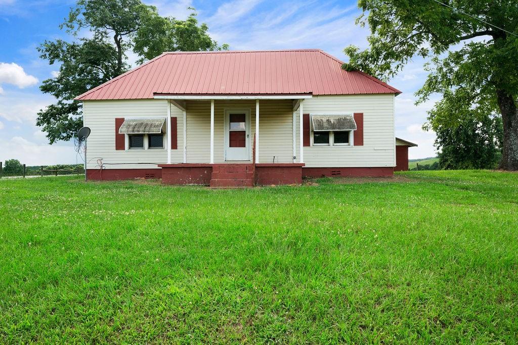 a front view of a house with a garden and yard