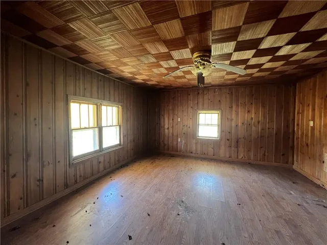 an empty room with windows and fan