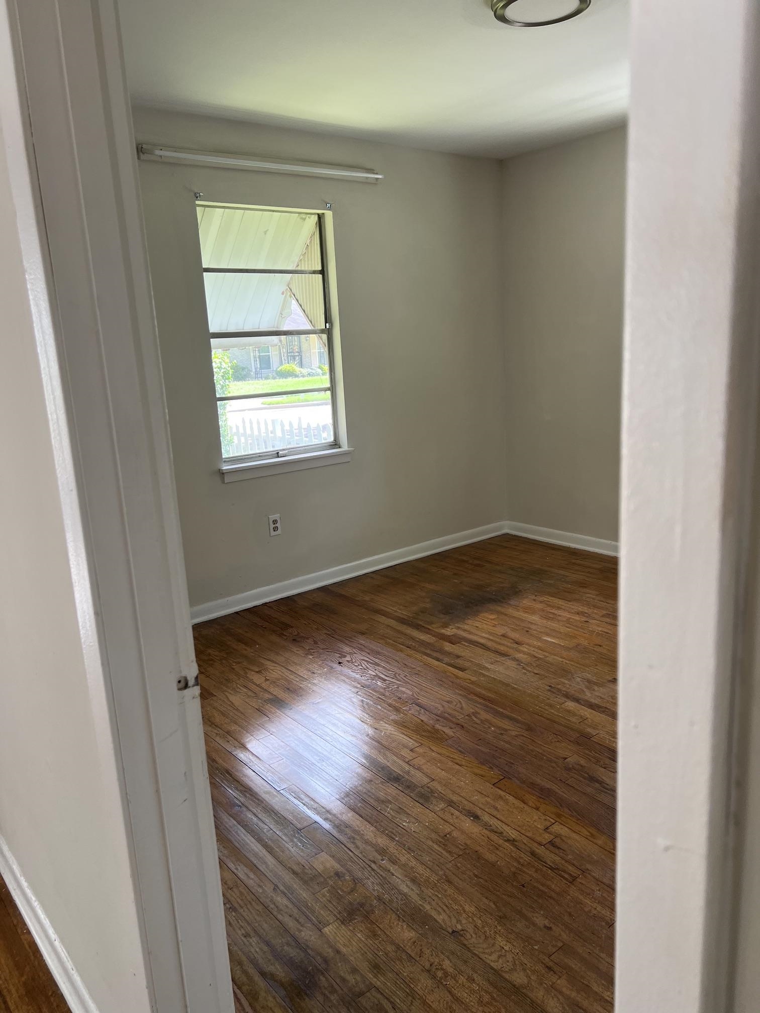 518 Harris Street Collierville, TN 38017 - Photo 11 of 13 Interior room featuring wood-finish flooring, light-toned walls, and a window with a white frame