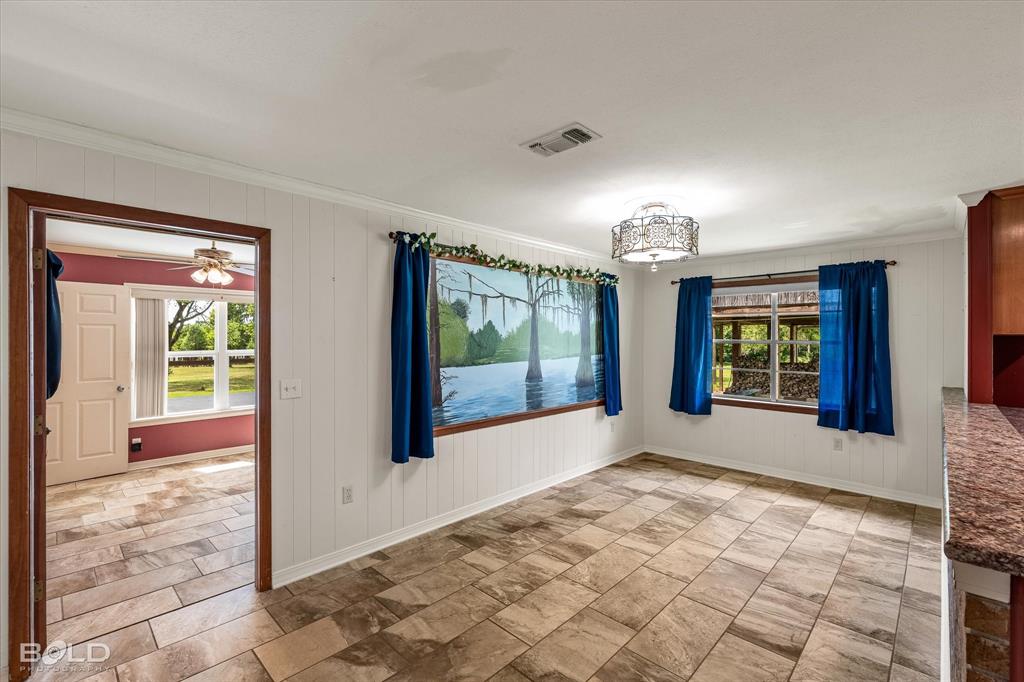 225 Marie Road Ringgold, LA 71068 - Photo 25 of 40 Spacious interior room featuring tile flooring, white vertical paneled walls, and a decorative ceiling light fixture