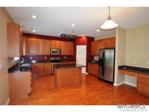 283 Wildbriar Road Fletcher, NC 28732 - Photo 3 of 13 a kitchen with stainless steel appliances granite countertop a refrigerator a sink dishwasher a stove and a sink with wooden floor