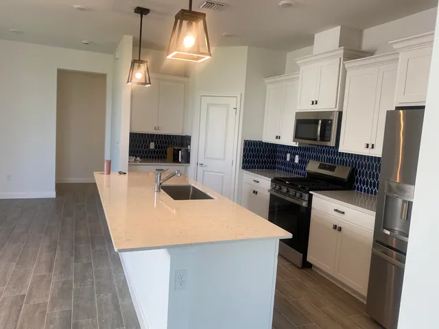 a kitchen with a sink a microwave a stove and refrigerator