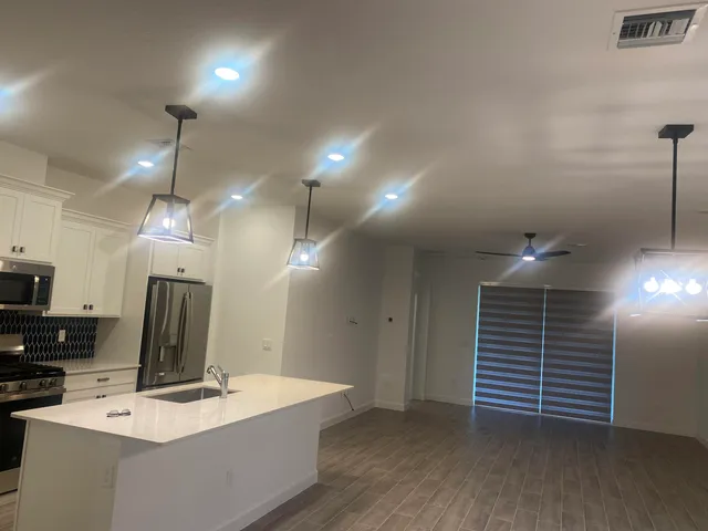 a kitchen with kitchen island stainless steel appliances a stove a sink a refrigerator and cabinets