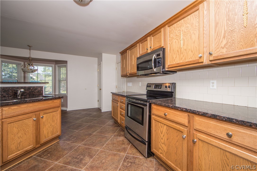 5300 Takach Road Prince George, VA 23875 - Photo 8 of 35 a kitchen with stainless steel appliances granite countertop a sink a stove a microwave and cabinets