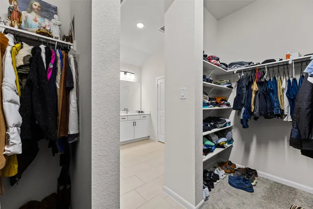a view of walk in closet with clothes and shoes
