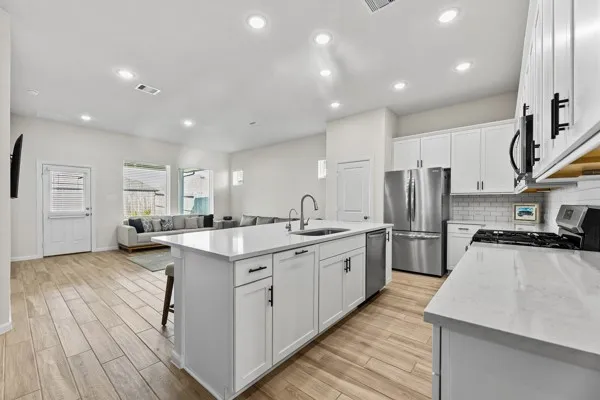 a kitchen with stainless steel appliances granite countertop a sink stove and refrigerator