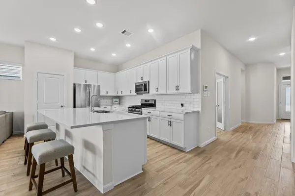a kitchen with white cabinets and stainless steel appliances