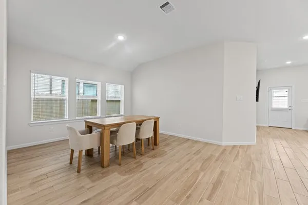 a dining room with furniture and wooden floor