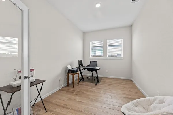 a view of a workspace with furniture and a window