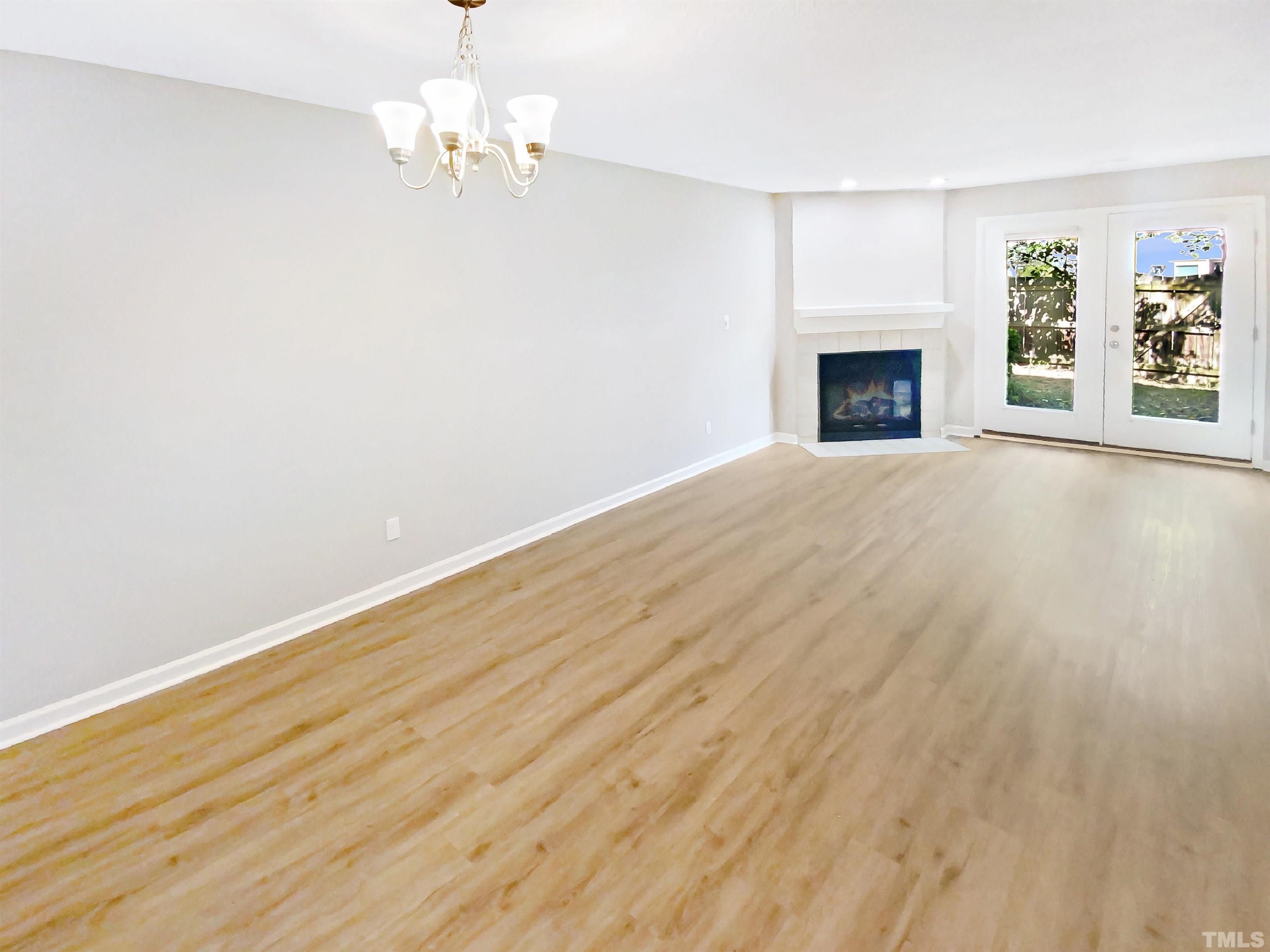 5634 Bridgetowne Way Raleigh, NC 27609 - Photo 3 of 18 an empty room with windows fireplace and a ceiling fan