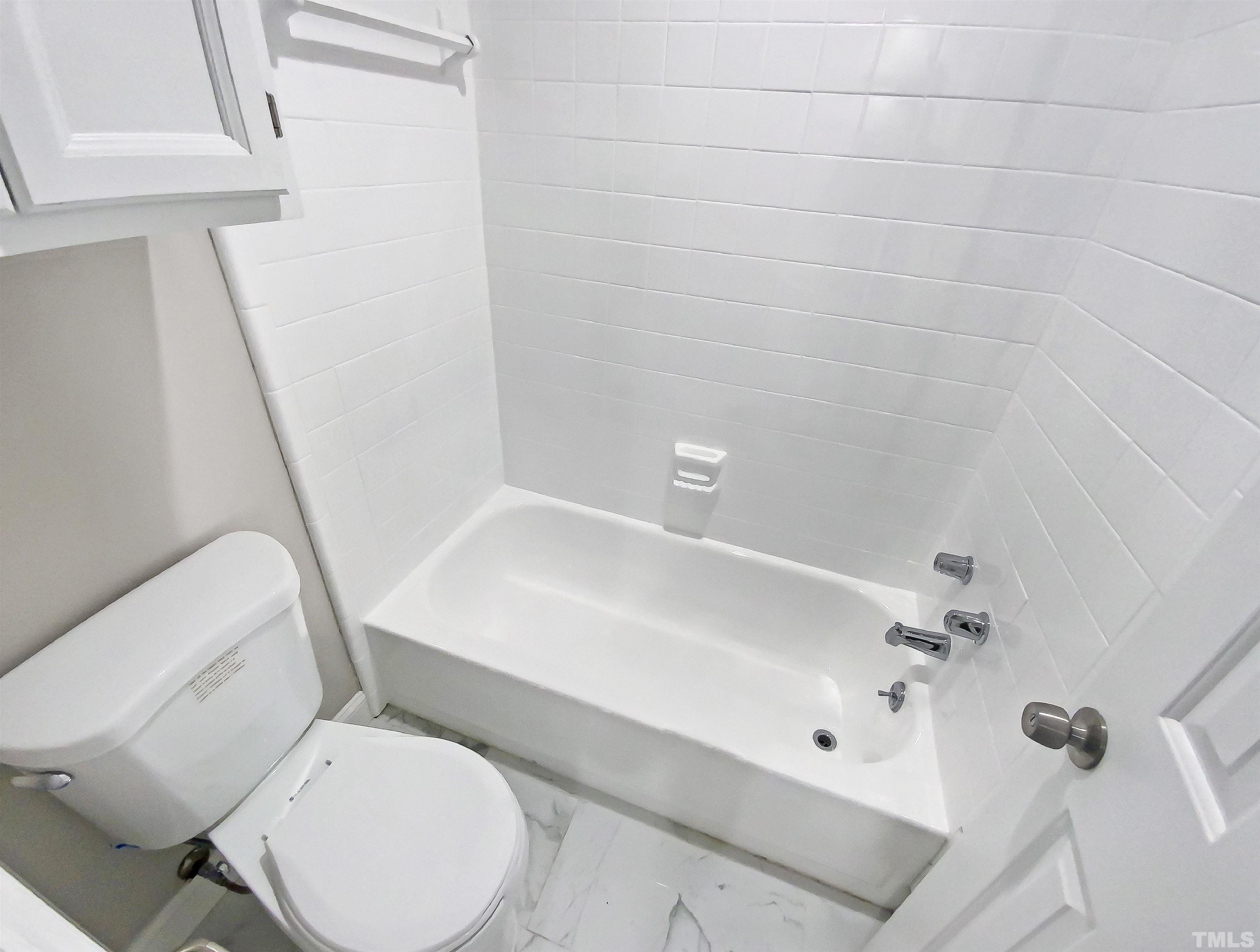 5634 Bridgetowne Way Raleigh, NC 27609 - Photo 8 of 18 a white toilet sitting next to a bath tub