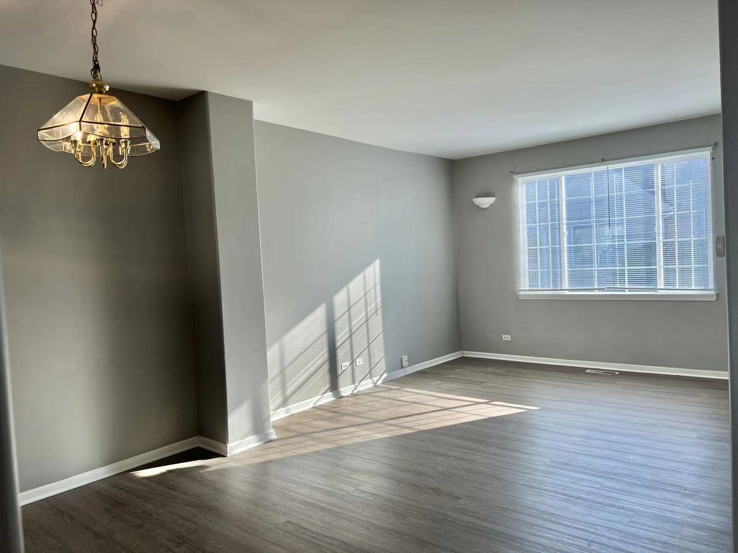 3367 Ravinia Circle Aurora, IL 60504 - Photo 2 of 14 an empty room with wooden floor cabinet and windows