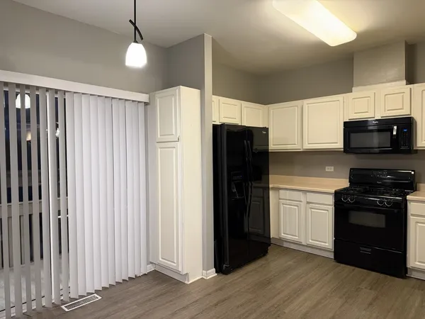 a kitchen with stainless steel appliances granite countertop a refrigerator a stove top oven a sink and dishwasher with wooden floor