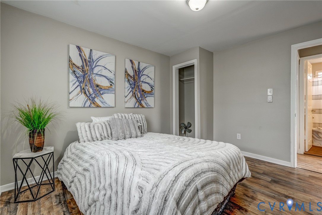 1411 Hopkins Road Richmond, VA 23224 - Photo 7 of 13 a bedroom with a large bed and a potted plant