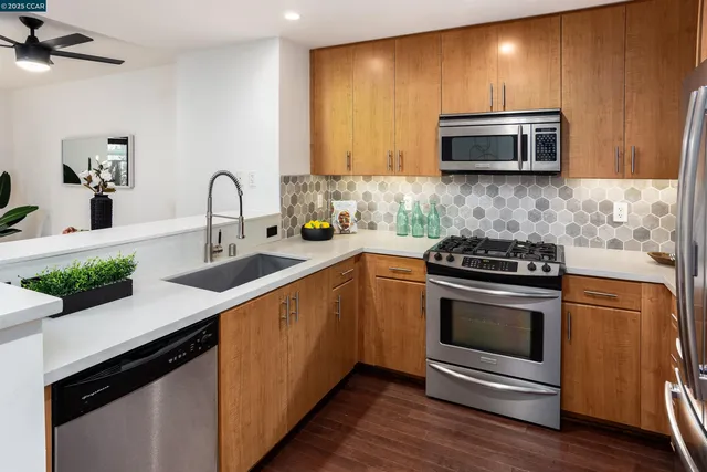 a kitchen with stainless steel appliances a stove microwave and sink
